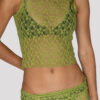 Model showing a zoomed-in detail of the "Lace Musgo Stretch" green top from the summer 23/24 Matte collection in a beach in Costa Rica