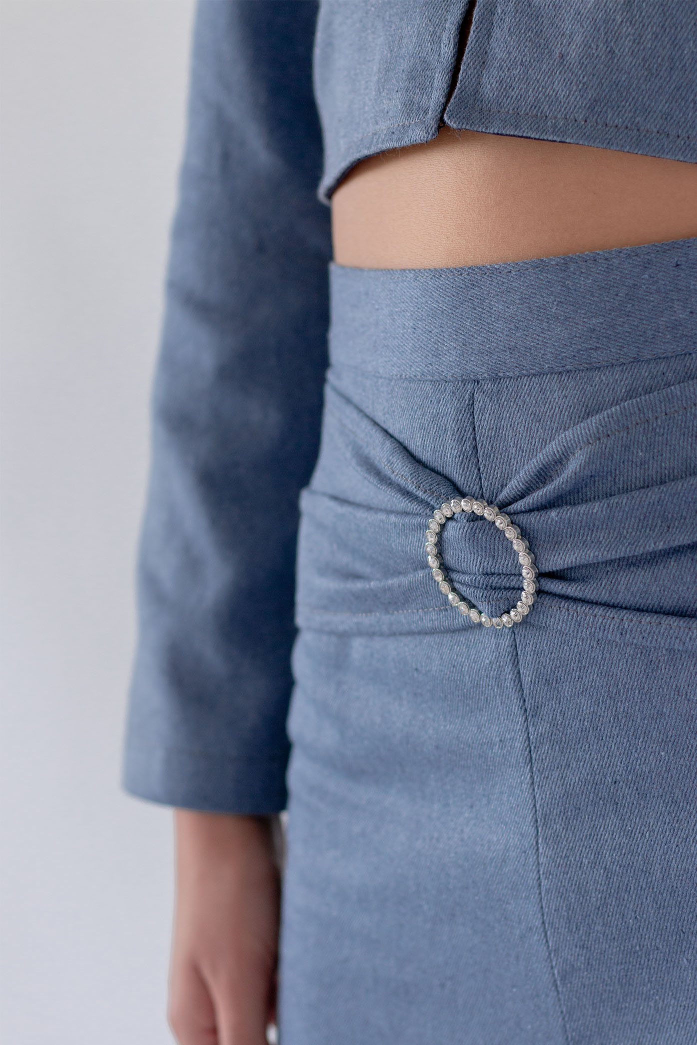 A zoomed-in detail of the beaded belt of the Cowboy Denim Midi Skirt at the studio, for the Summer 23/24 Matte Collection